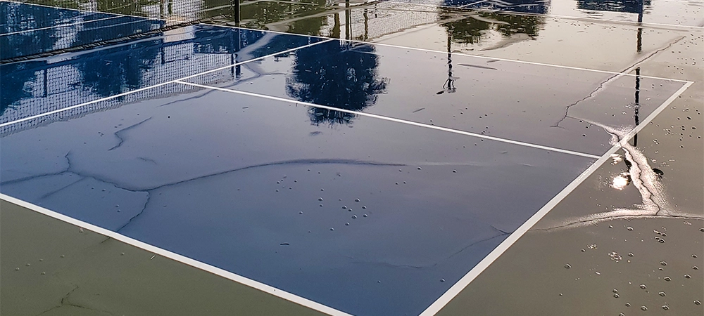 cracks and water demage in pickleball court