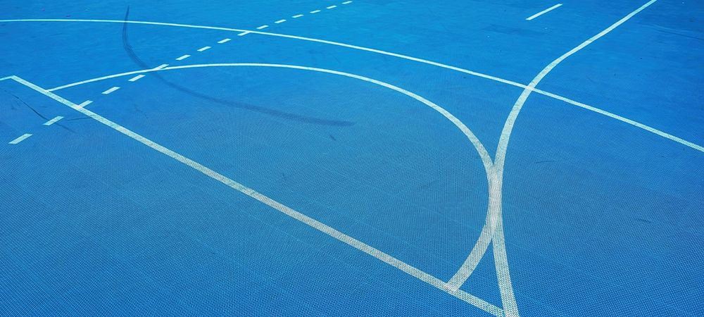 Outdoor basketball sport court line marking with non-slip plastic surface as abstract background, selective focus