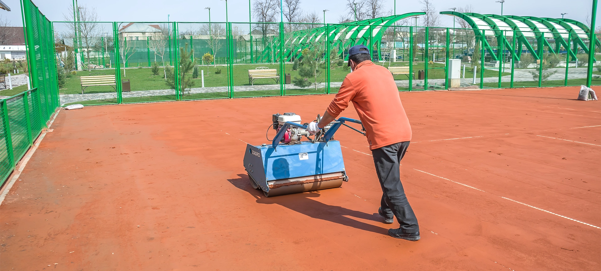 man repairing clay sport court