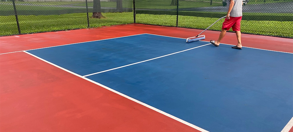 man resurfacing the sport court