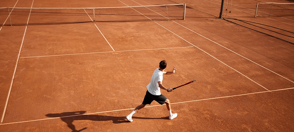 tennis player in motion on clay court with racket