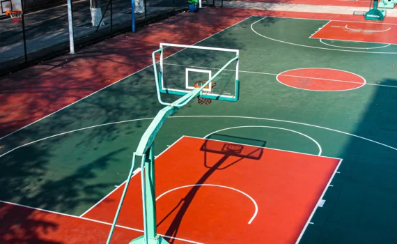 Open college basketball court, with bright colors, illuminated by the warm noon sunshine.