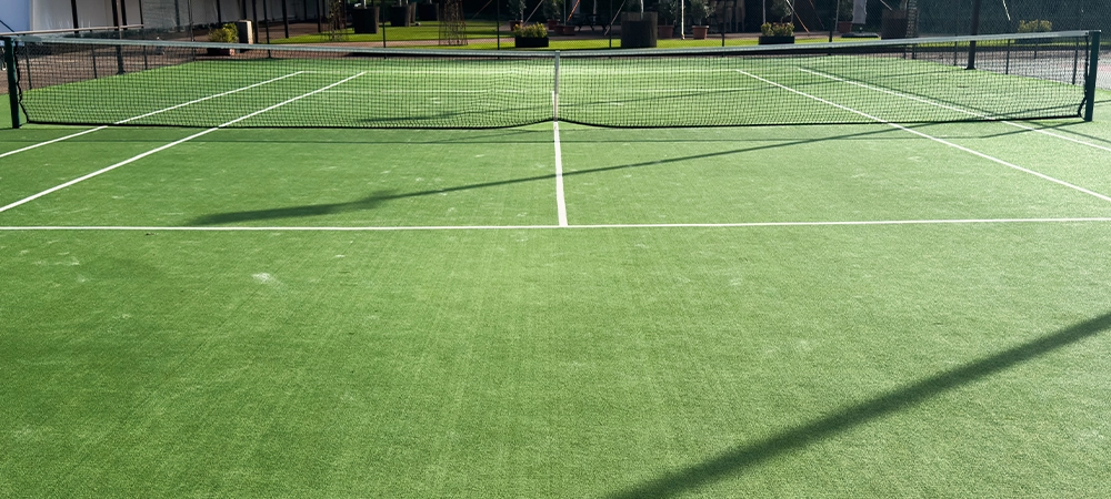 Green tennis court that is empty