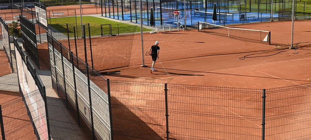 the surface of the tennis court is leveled after the game by a maintenance worker