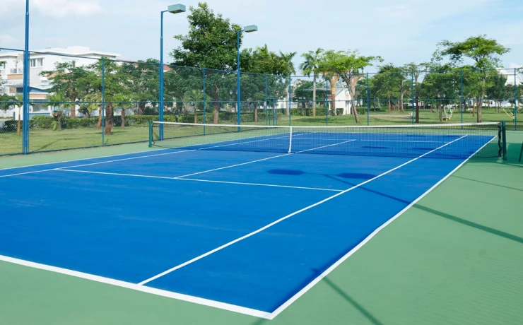 The tennis court is empty in a luxurious villa complex