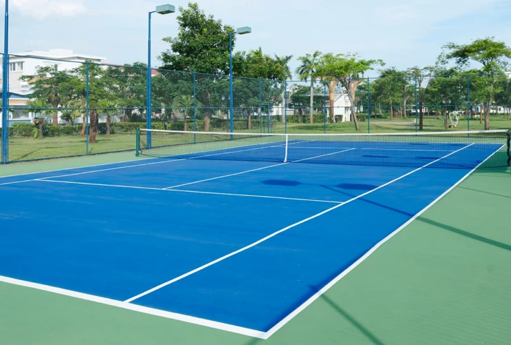 The tennis court is empty in a luxurious villa complex