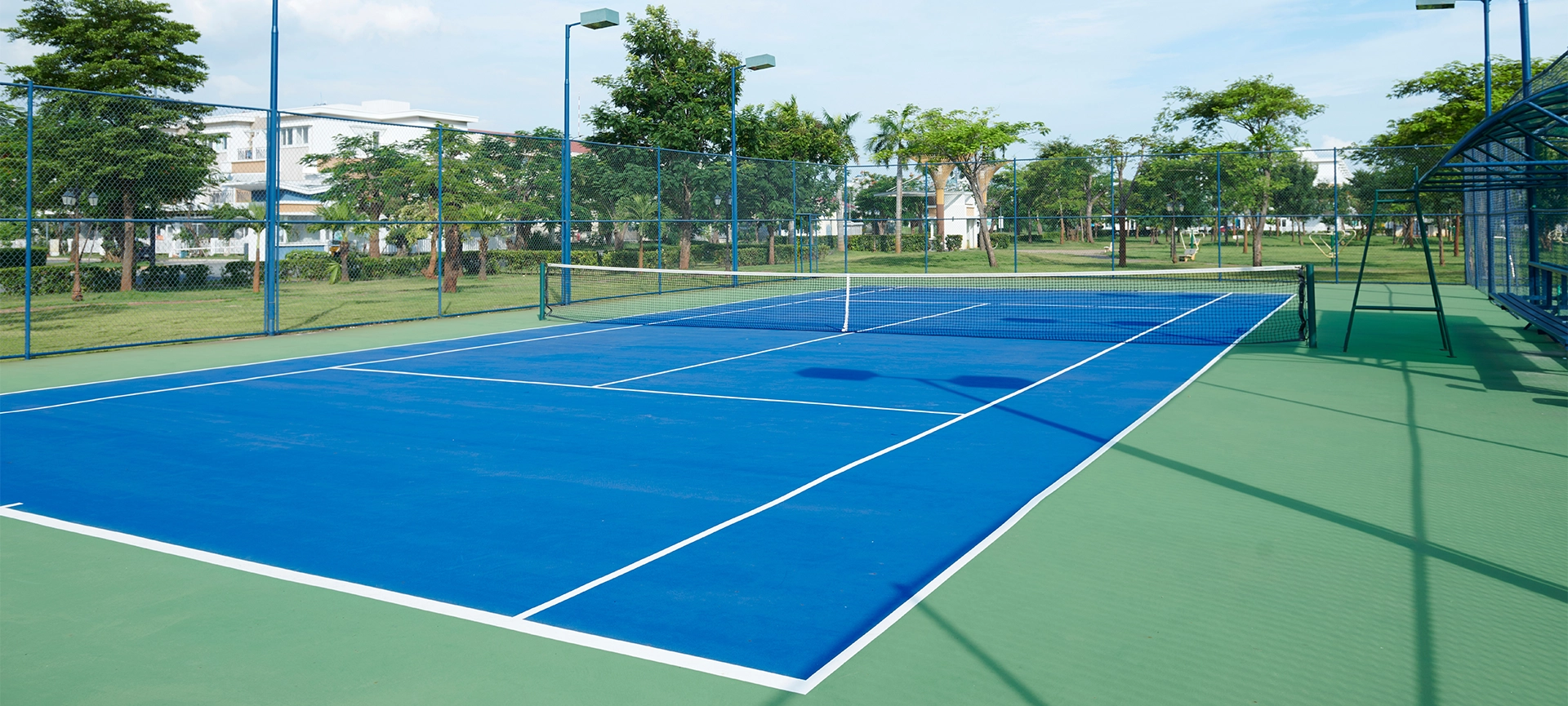The tennis court is empty in a luxurious villa complex