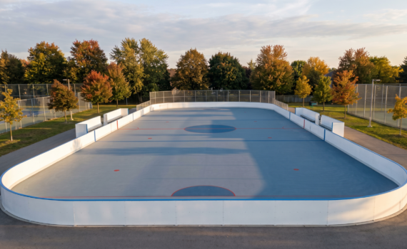 Newly finished outdoor roller hockey court with white dasher boards in an Ontario setting