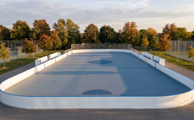 Newly finished outdoor roller hockey court with white dasher boards in an Ontario setting