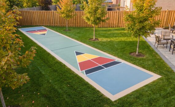 A newly finished outdoor shuffleboard court with an acrylic-coated surface and painted scoring zones in an Ontario backyard